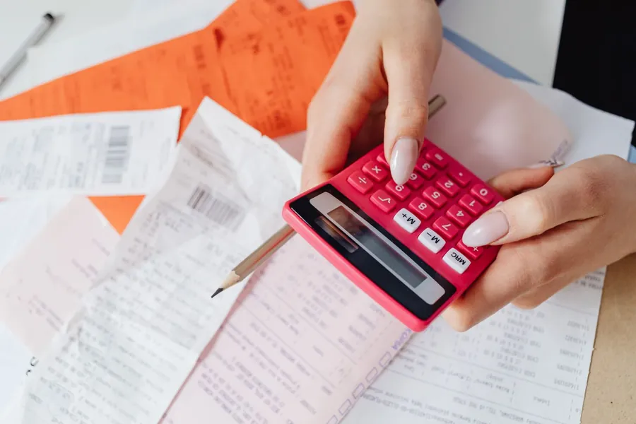 Calculator and receipts used to work out flat roof replacement costs for a Croydon house