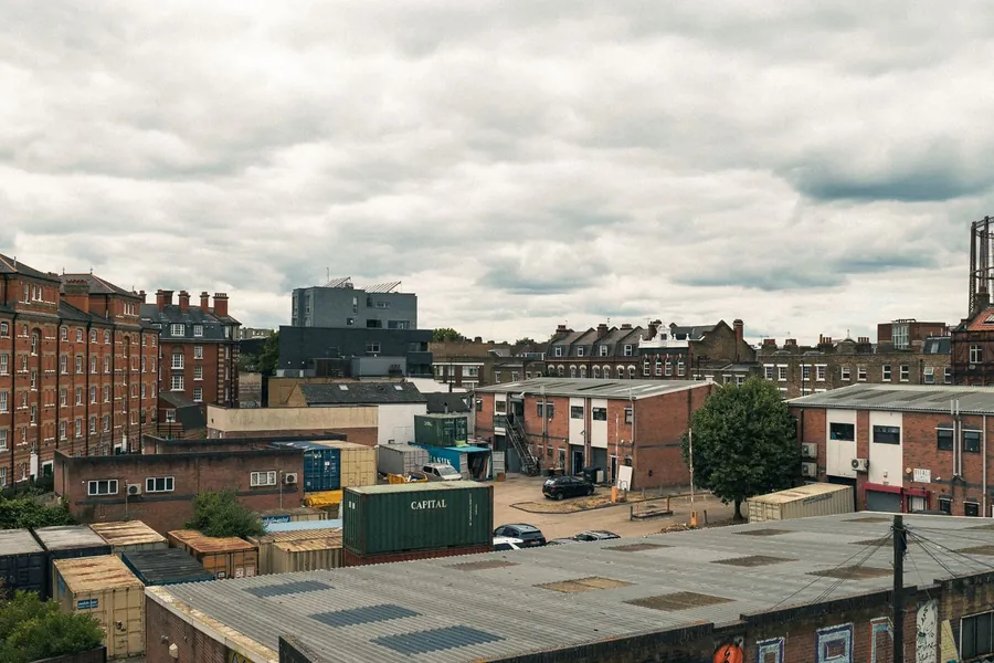 London rooftops showing broad flat roofs among brick terraces, the kind of covering that needs stripping back to the deck rather than another recover