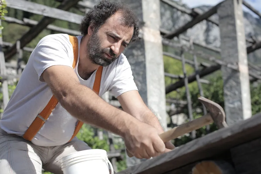 Roofer working with a hammer on scaffolding during a roof repair