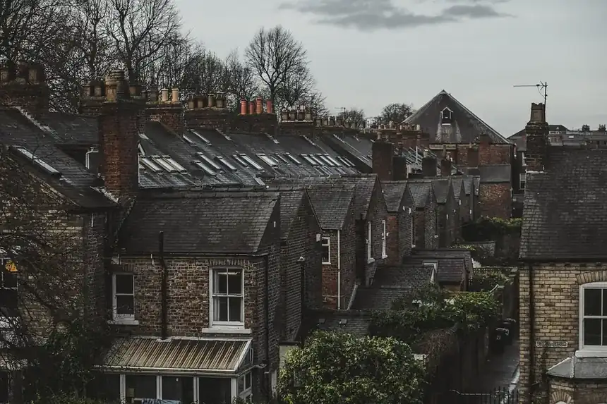 Rows of terraced rooftops with dormers, skylights and chimneys seen from above
