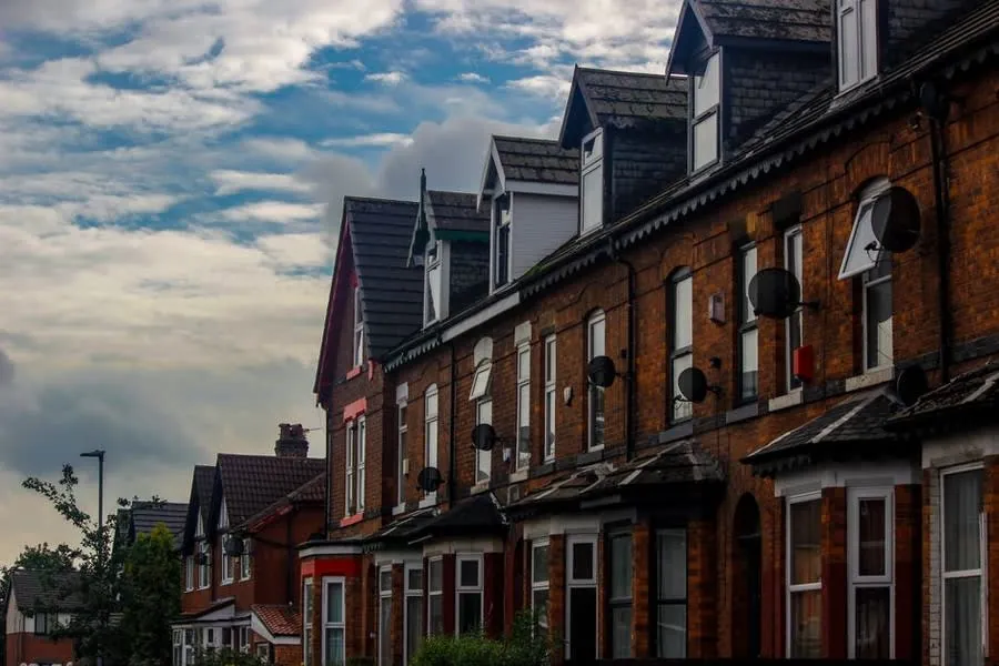 Row of Victorian brick terraced houses with slate roofs and gable dormers on a Croydon street