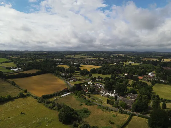 Aerial view over fields, hedgerows and woodland seen from high ground above the Weald