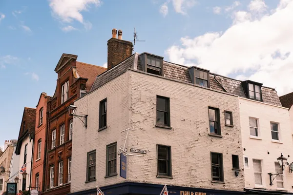 Old brick and painted buildings on a high street corner in south east England