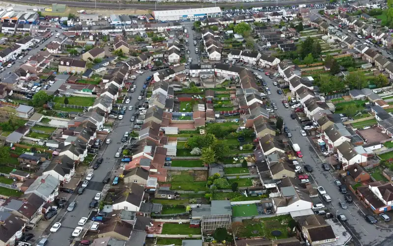 Aerial view of an estate of semi-detached and terraced houses laid out along curving roads