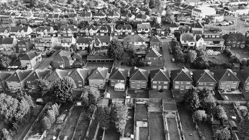 Black and white aerial view of rows of semi-detached houses and their hipped roofs