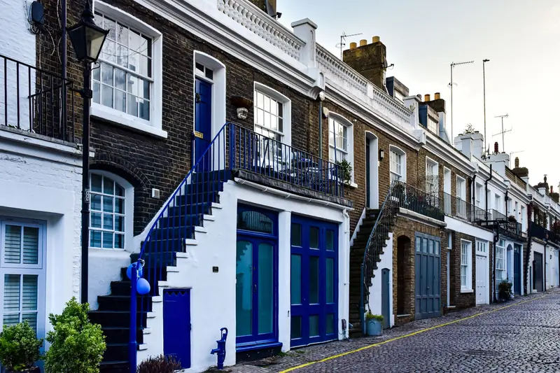 Row of London terraced houses with steps up to the front doors and brick chimneys