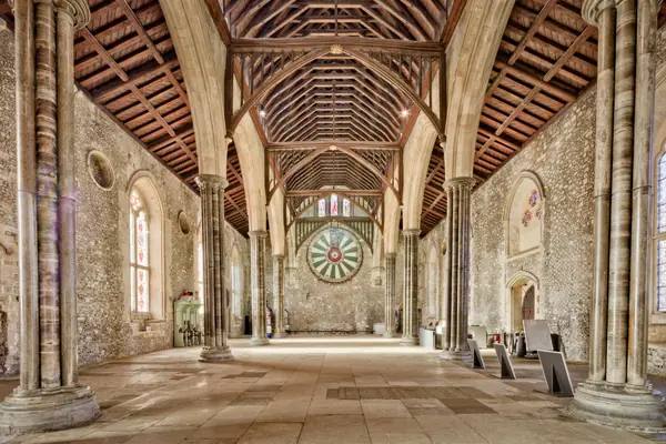 Medieval great hall interior with an open timber roof and tall windows